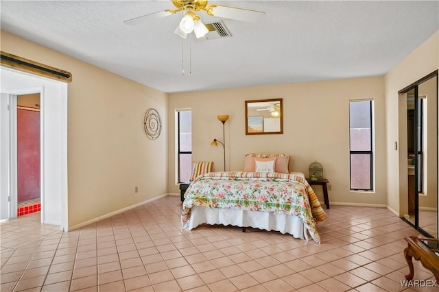 bedroom with a barn door, baseboards, ceiling fan, and light tile patterned flooring