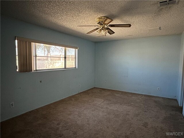 empty room with carpet floors, visible vents, a textured ceiling, and a ceiling fan