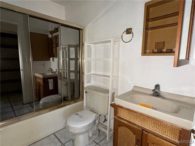 full bath featuring enclosed tub / shower combo, toilet, vanity, and tile patterned floors