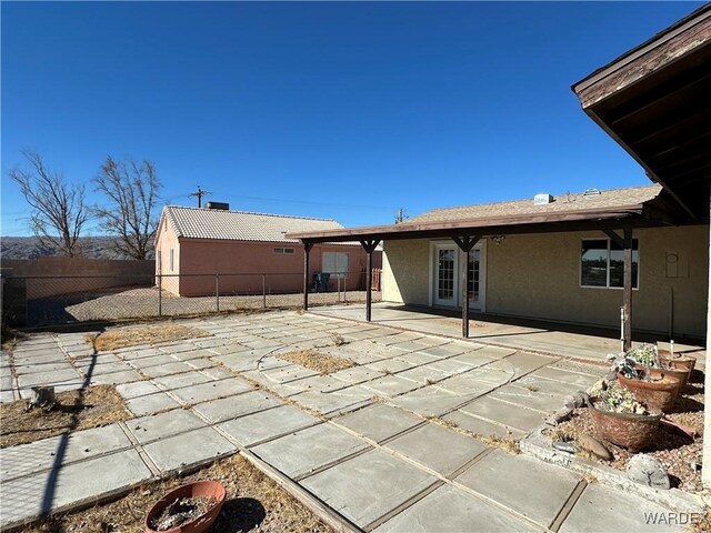 rear view of house featuring a patio, fence, and stucco siding