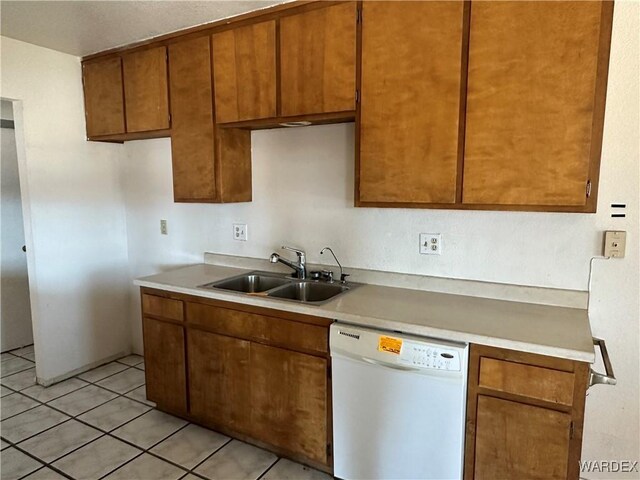 kitchen featuring brown cabinets, light countertops, dishwasher, and a sink