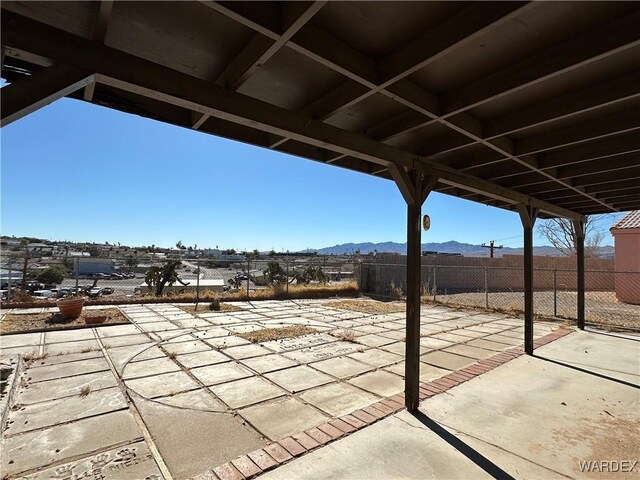 view of patio featuring a mountain view and fence