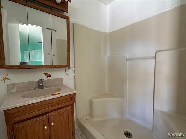 full bathroom with a stall shower and vanity