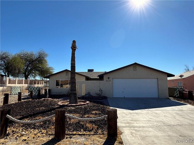 ranch-style home featuring a garage, concrete driveway, fence, and stucco siding