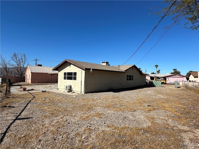 rear view of property with fence and stucco siding