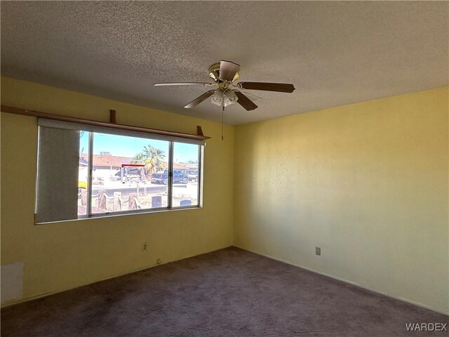 carpeted spare room with a textured ceiling and a ceiling fan