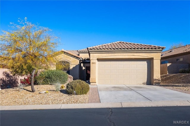 mediterranean / spanish-style house with concrete driveway, a tile roof, an attached garage, and stucco siding