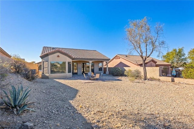 mediterranean / spanish home with a patio area, a fenced backyard, stucco siding, and a tiled roof