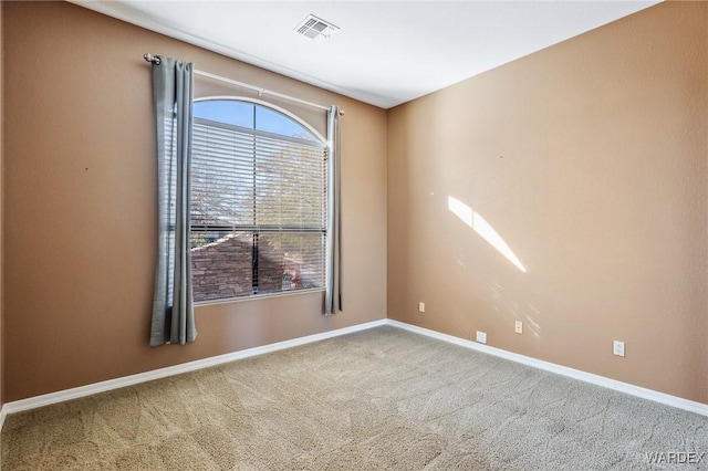 carpeted empty room with visible vents and baseboards