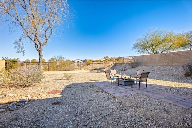 view of yard featuring a fenced backyard, a fire pit, and a patio