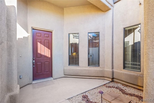 property entrance featuring a patio area and stucco siding