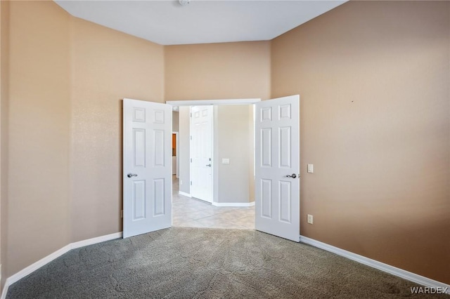 unfurnished bedroom with light colored carpet and baseboards