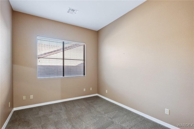 carpeted spare room with visible vents and baseboards