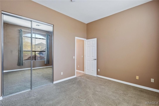 unfurnished bedroom with carpet floors, a closet, and baseboards