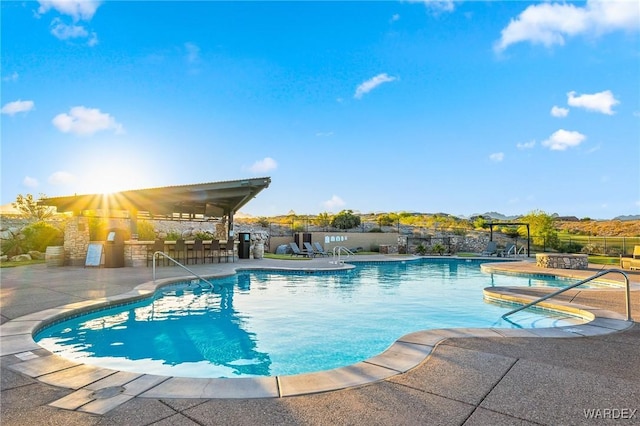 pool featuring fence and a patio