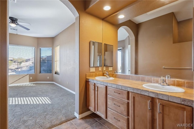 bathroom with a ceiling fan, tile patterned flooring, a sink, and double vanity