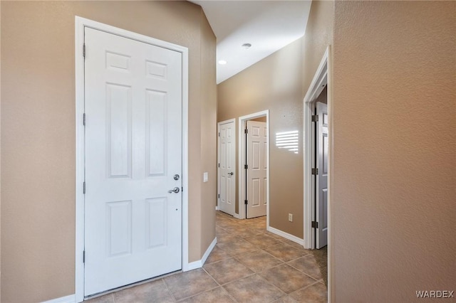 corridor featuring baseboards and light tile patterned floors