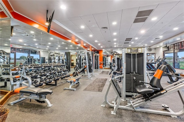 gym featuring a paneled ceiling, visible vents, and a city view