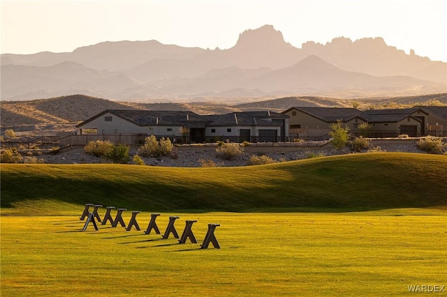 view of property's community with a mountain view and a lawn