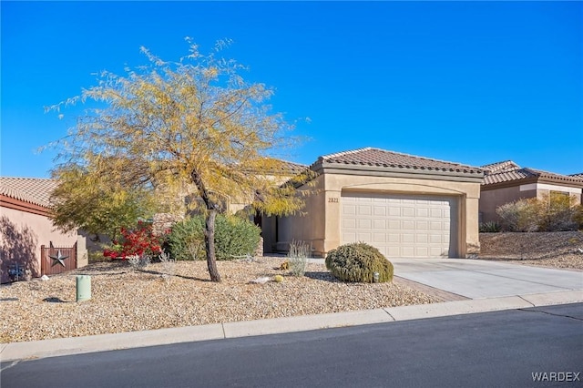 view of front facade with driveway, stucco siding, an attached garage, and a tiled roof