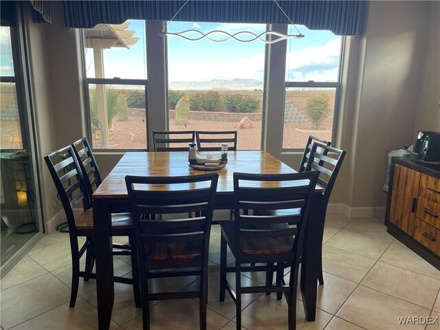 dining room with light tile patterned flooring and baseboards