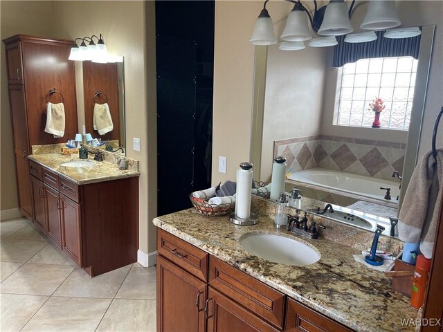 full bathroom featuring a bath, two vanities, a sink, and tile patterned floors