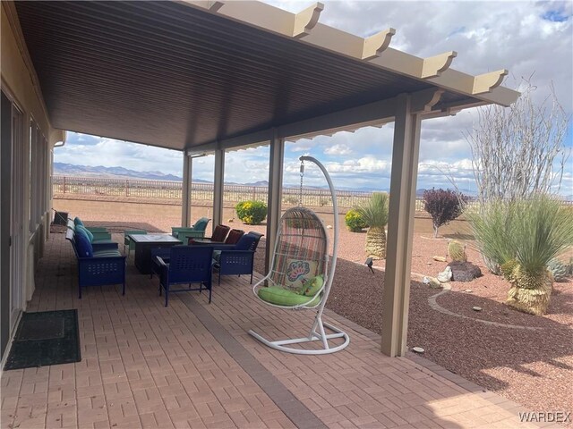 view of patio / terrace with fence and a mountain view