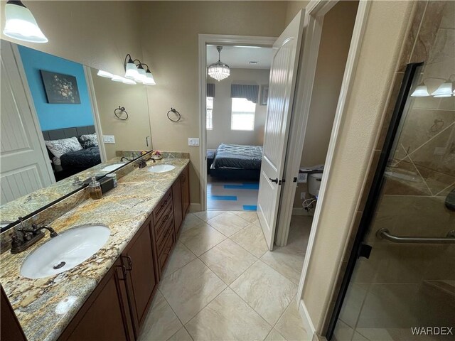 ensuite bathroom with double vanity, a shower stall, a sink, and ensuite bathroom