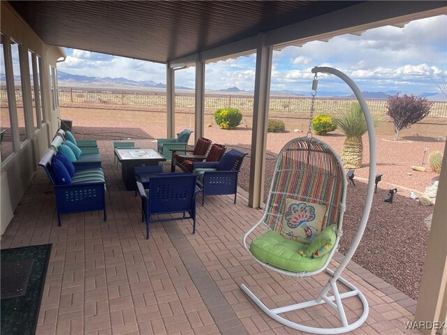 view of patio / terrace featuring an outdoor hangout area, a rural view, a fenced backyard, and a mountain view