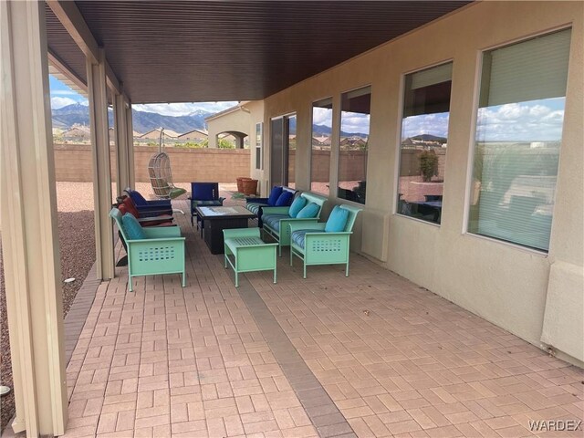 view of patio / terrace featuring radiator, a fenced backyard, a mountain view, and an outdoor hangout area