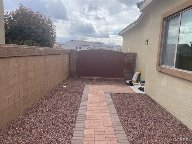 view of yard featuring a patio area, a fenced backyard, and a gate