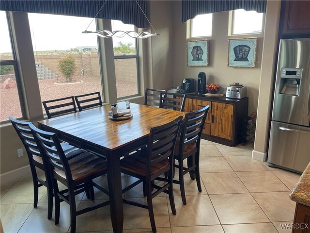 dining area featuring a healthy amount of sunlight, baseboards, and light tile patterned floors