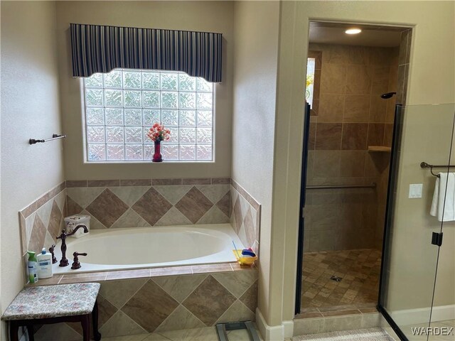 bathroom with a garden tub and a shower stall