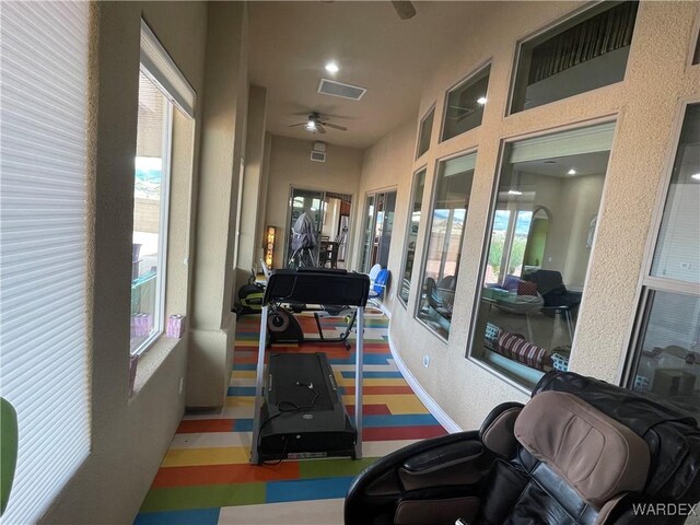 workout room featuring baseboards, a wealth of natural light, visible vents, and a ceiling fan