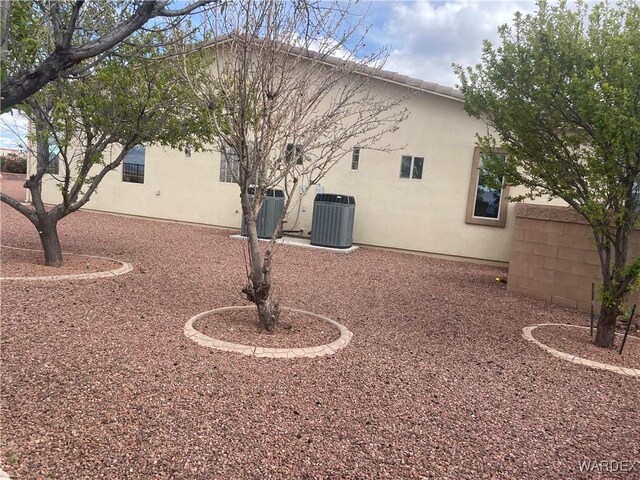 exterior space with cooling unit and stucco siding