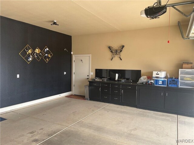 garage featuring a garage door opener and baseboards