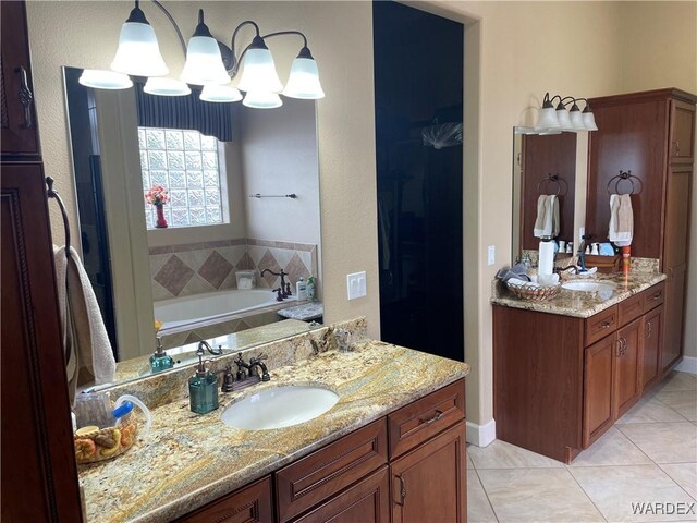 full bath featuring a garden tub, two vanities, a sink, and tile patterned flooring