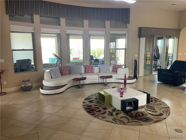 living room featuring a healthy amount of sunlight, light tile patterned floors, and baseboards