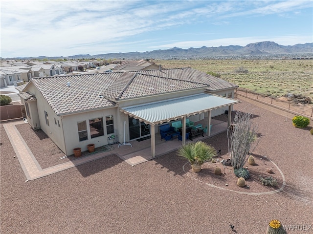 back of house featuring a tiled roof, a patio area, fence, and a mountain view