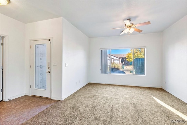 unfurnished room featuring a ceiling fan, carpet flooring, and baseboards