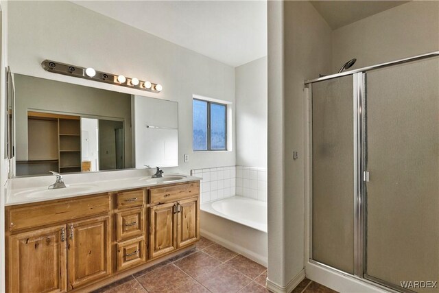 full bathroom featuring a stall shower, a garden tub, and a sink