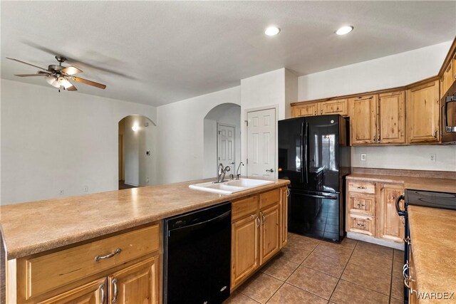 kitchen featuring black appliances, light countertops, a sink, and tile patterned floors