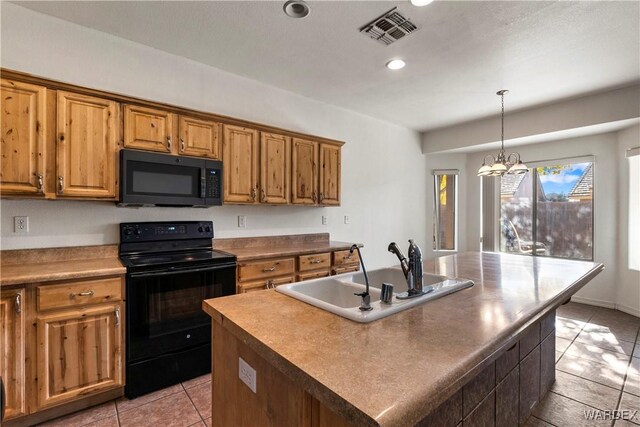 kitchen with a center island with sink, visible vents, brown cabinetry, black appliances, and a sink