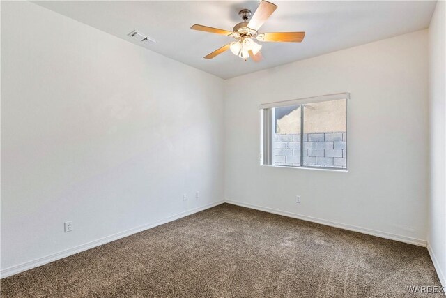 carpeted spare room featuring ceiling fan, visible vents, and baseboards