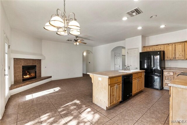 kitchen featuring a center island with sink, light countertops, visible vents, open floor plan, and black appliances