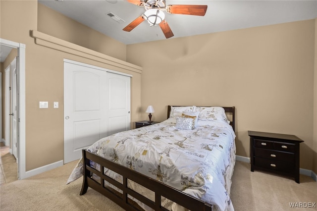 bedroom with a closet, visible vents, a ceiling fan, light carpet, and baseboards