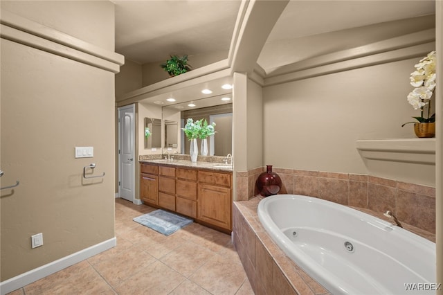 bathroom with double vanity, a sink, tile patterned flooring, baseboards, and a tub with jets