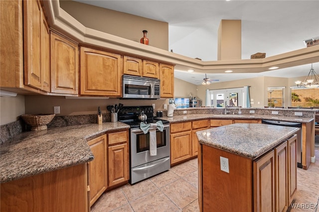 kitchen featuring stainless steel appliances, brown cabinetry, light tile patterned flooring, a kitchen island, and a peninsula