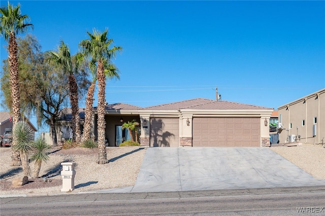 view of front of house featuring stone siding, driveway, an attached garage, and stucco siding