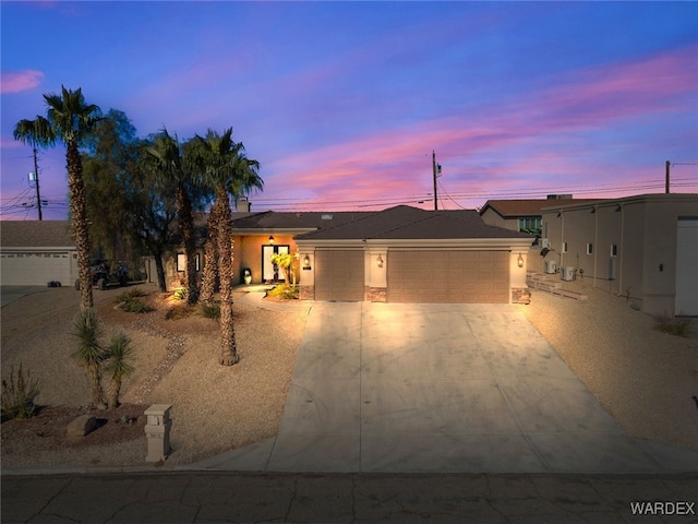 view of front facade featuring a garage, concrete driveway, and stucco siding